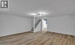 Finished below grade area with stairway and light wood-style floors -