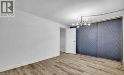 Spare room featuring light wood-style floors, a chandelier, and an accent wall -