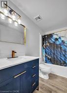 Bathroom featuring vanity, light wood-style flooring, and shower / bath combo with shower curtain -
