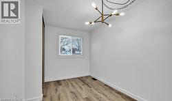 Spare room featuring light wood-style flooring and a chandelier -