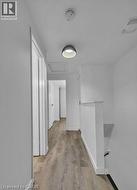 Hallway featuring an upstairs landing and light wood finished floors -
