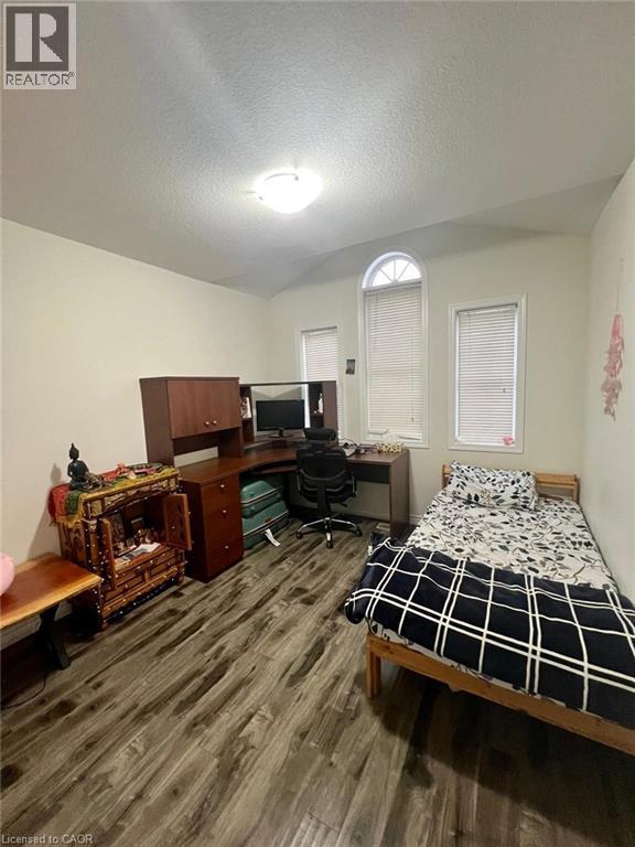 Bedroom with a desk, a textured ceiling, and dark wood finished floors - 128 Watermill Street, Kitchener, ON - Indoor Photo Showing Bedroom