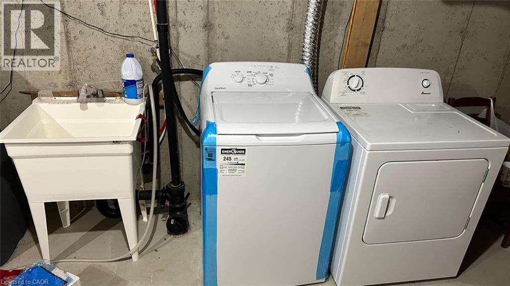 Washroom featuring unfinished concrete flooring and independent washer and dryer - 128 Watermill Street, Kitchener, ON - Indoor Photo Showing Laundry Room