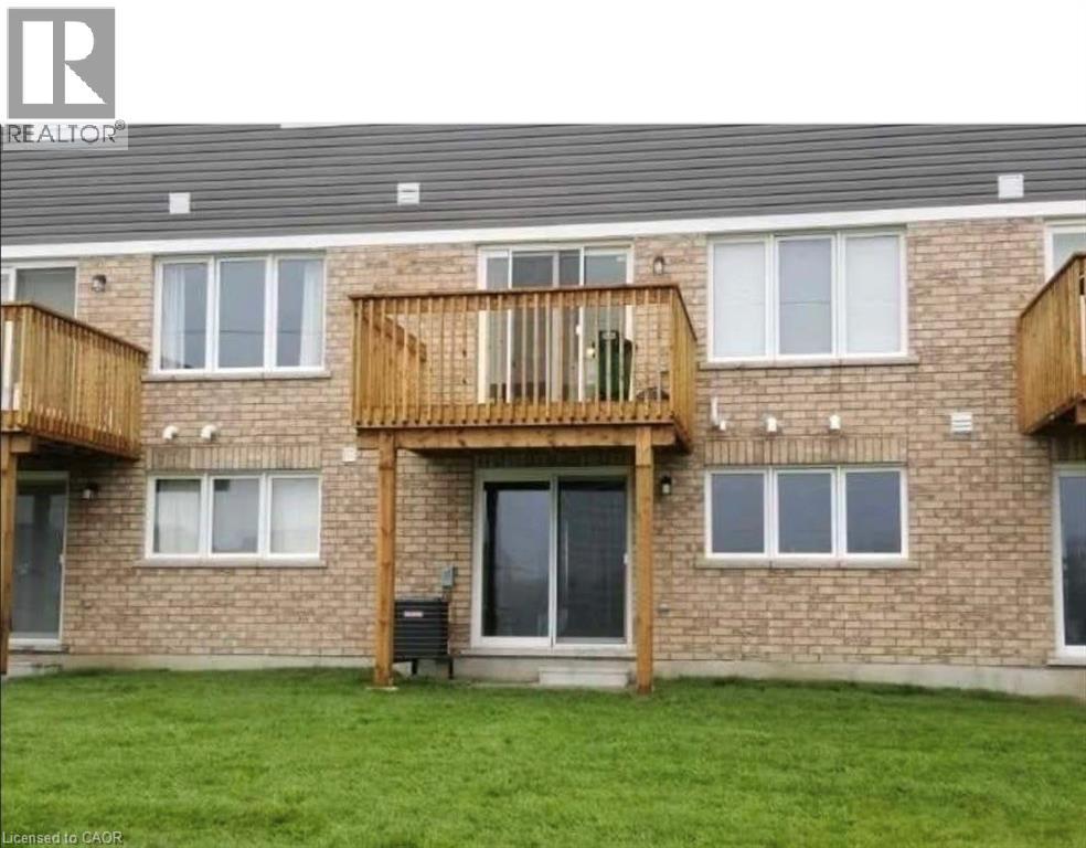 Back of property with a balcony, brick siding, and a lawn - 128 Watermill Street, Kitchener, ON - Outdoor With Exterior