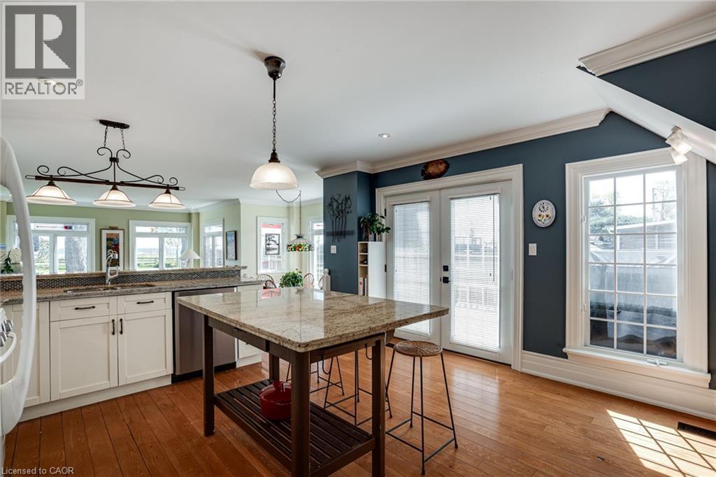 Kitchen with white cabinets, decorative light fixtures, dishwasher, french doors, and light stone countertops - 849 Beach Boulevard, Hamilton, ON - Indoor