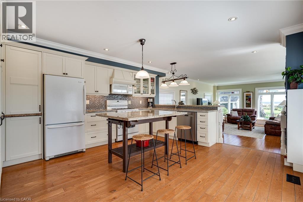 Kitchen featuring white appliances, glass insert cabinets, open floor plan, decorative light fixtures, and white cabinets - 849 Beach Boulevard, Hamilton, ON - Indoor Photo Showing Kitchen