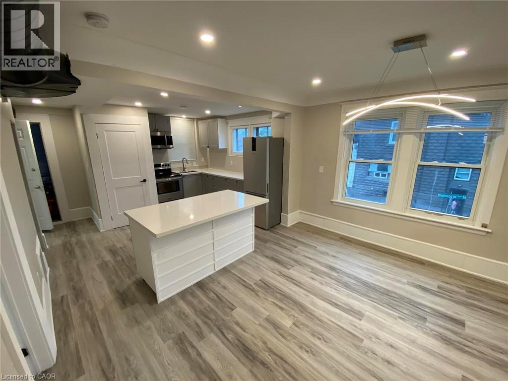 Kitchen featuring light countertops, appliances with stainless steel finishes, light wood-type flooring, a center island, and recessed lighting - 193 Balmoral Avenue N, Hamilton, ON - Indoor Photo Showing Other Room