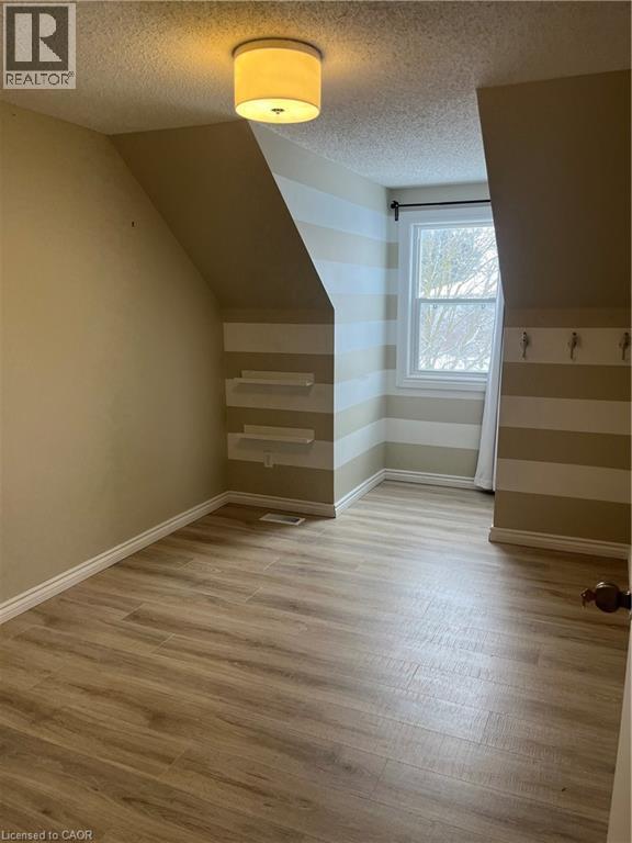 Bonus room featuring light wood-style floors, a textured ceiling, and vaulted ceiling - 236 Bankside Drive, Kitchener, ON - Indoor Photo Showing Other Room