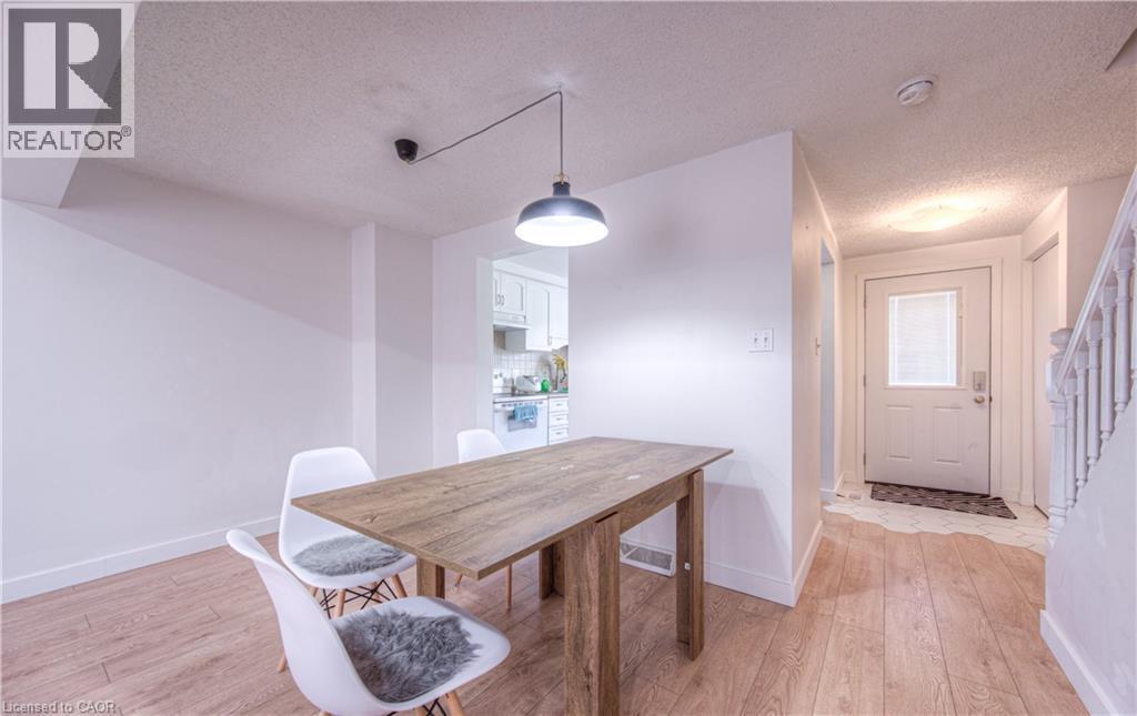 Dining area with a textured ceiling and light wood-style flooring - 236 Bankside Drive, Kitchener, ON - Indoor Photo Showing Dining Room