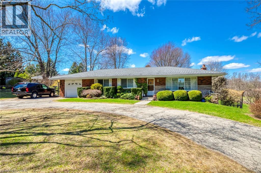 Ranch-style home with a chimney, a front lawn, driveway, and a garage - 1215 Britannia Road, Burlington, ON
