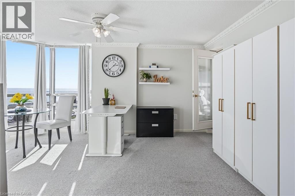 Office space with floor to ceiling windows, light colored carpet, ceiling fan, crown molding, and a textured ceiling - 2170 Marine Drive Unit# 1808, Oakville, ON - Indoor Photo Showing Other Room