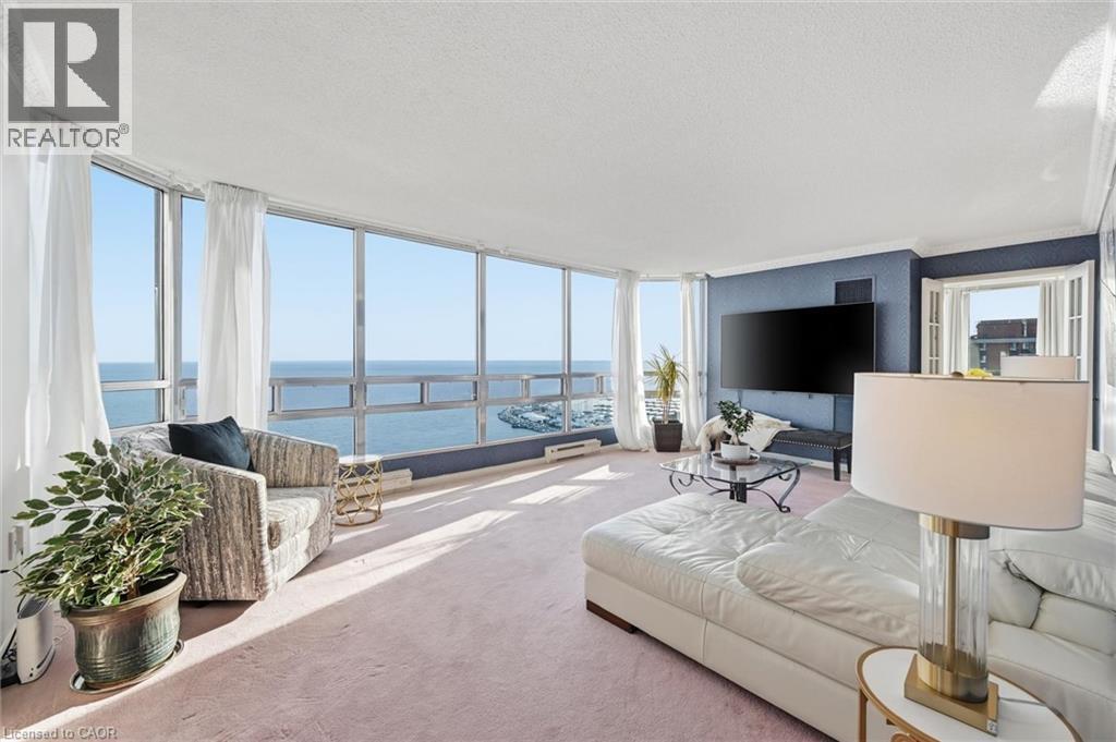 Carpeted living area featuring a water view, floor to ceiling windows, plenty of natural light, and a textured ceiling - 2170 Marine Drive Unit# 1808, Oakville, ON - Indoor Photo Showing Living Room