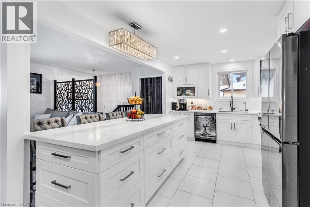 Kitchen with white cabinetry, freestanding refrigerator, open floor plan, light stone countertops, and dishwasher - 136 Limpert Avenue, Cambridge, ON - Indoor Photo Showing Kitchen With Upgraded Kitchen