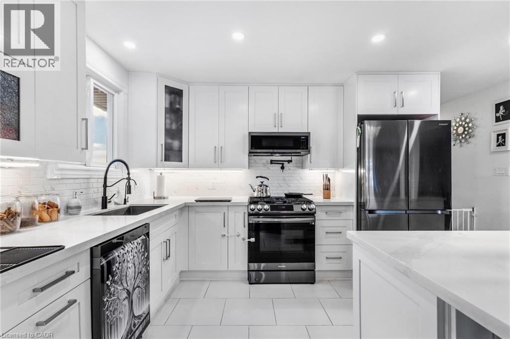 Kitchen featuring appliances with stainless steel finishes, white cabinets, light stone countertops, recessed lighting, and light tile patterned flooring - 136 Limpert Avenue, Cambridge, ON - Indoor Photo Showing Kitchen With Upgraded Kitchen