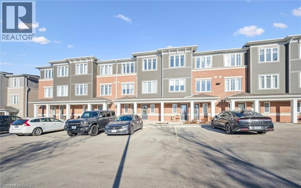 View of building exterior featuring uncovered parking and a residential view - 24 Morrison Road Unit# D9, Kitchener, ON - Outdoor With Facade