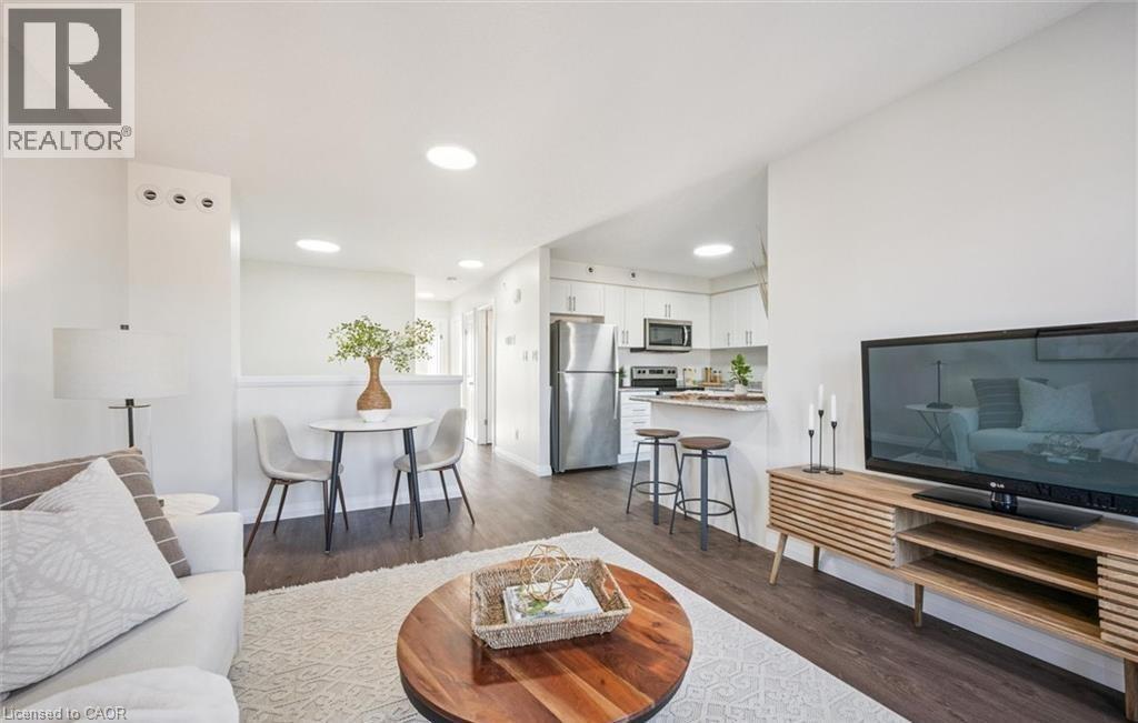Living room with dark wood-style floors and recessed lighting - 24 Morrison Road Unit# D9, Kitchener, ON - Indoor Photo Showing Living Room