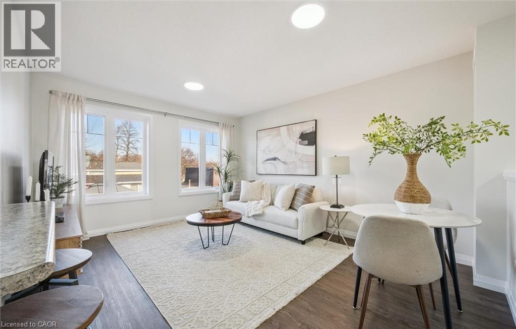 Living area featuring dark wood-style flooring and recessed lighting - 24 Morrison Road Unit# D9, Kitchener, ON - Indoor Photo Showing Living Room