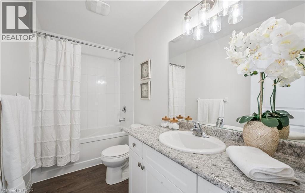 Bathroom with vanity, shower / bathtub combination with curtain, and dark wood-style flooring - 24 Morrison Road Unit# D9, Kitchener, ON - Indoor Photo Showing Bathroom