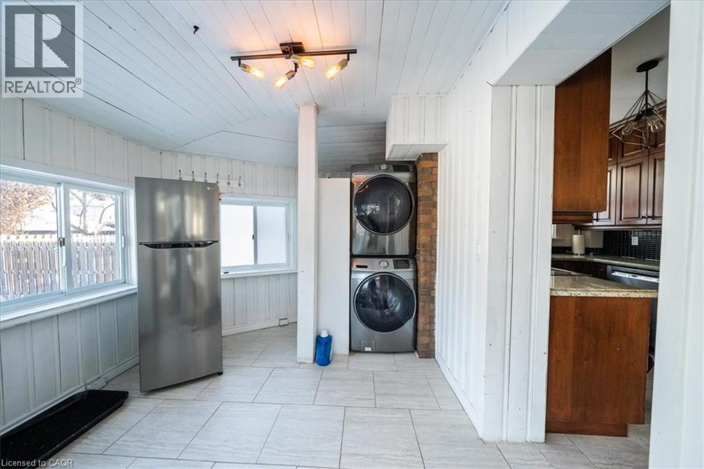 Laundry area featuring vaulted ceiling, stacked washer / dryer, wooden walls, and wood ceiling - 184 Weber Street E, Kitchener, ON - Indoor