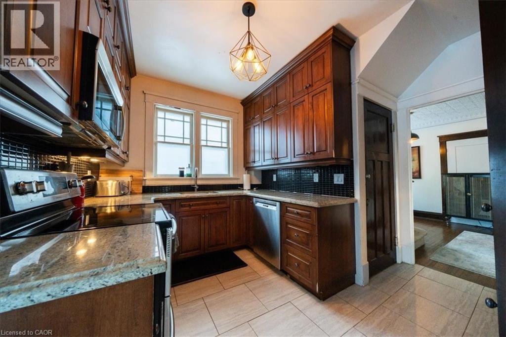 Kitchen featuring stainless steel appliances, tasteful backsplash, pendant lighting, light stone countertops, and light tile patterned floors - 184 Weber Street E, Kitchener, ON - Indoor Photo Showing Kitchen