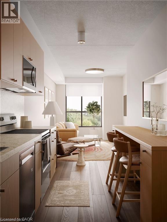 Kitchen featuring appliances with stainless steel finishes, light countertops, a textured ceiling, dark wood-style floors, and open floor plan - 580 Coldstream Drive Unit# 310, Waterloo, ON - Indoor Photo Showing Kitchen With Stainless Steel Kitchen