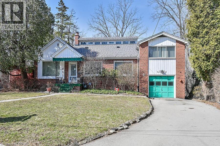 View of front of home with a front lawn, asphalt driveway, a garage, brick siding, and a chimney - 9 Daleview Court, Hamilton, ON - Outdoor