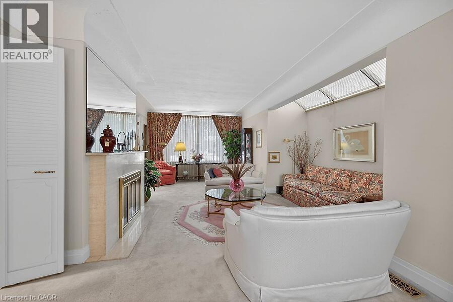 Living area featuring light carpet and a glass covered fireplace - 9 Daleview Court, Hamilton, ON - Indoor Photo Showing Other Room
