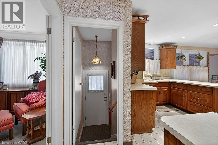 Kitchen featuring light countertops, wood finish cabinets, a peninsula, and pendant lighting - 9 Daleview Court, Hamilton, ON - Indoor