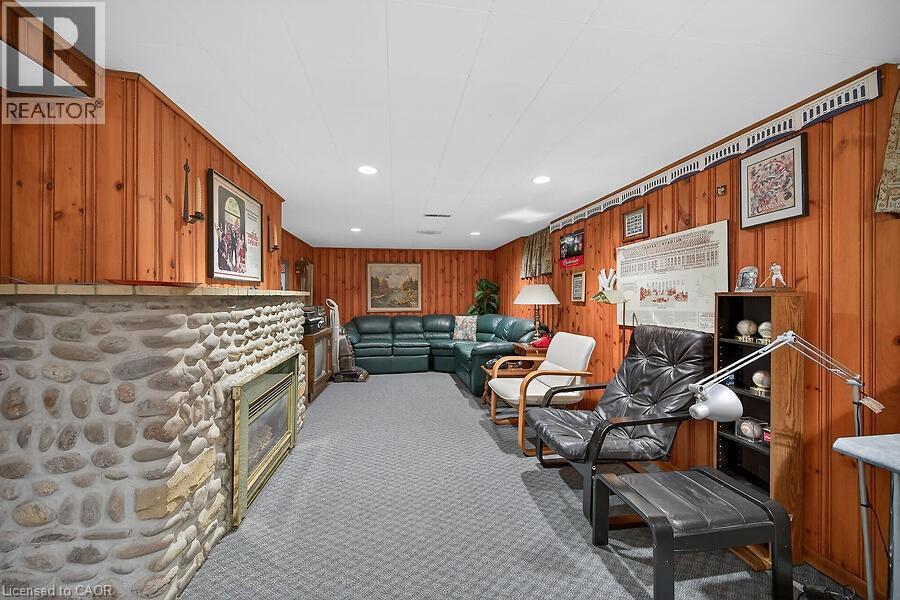 Living area with carpet floors, recessed lighting, wooden walls, and a glass covered fireplace - 9 Daleview Court, Hamilton, ON - Indoor Photo Showing Other Room