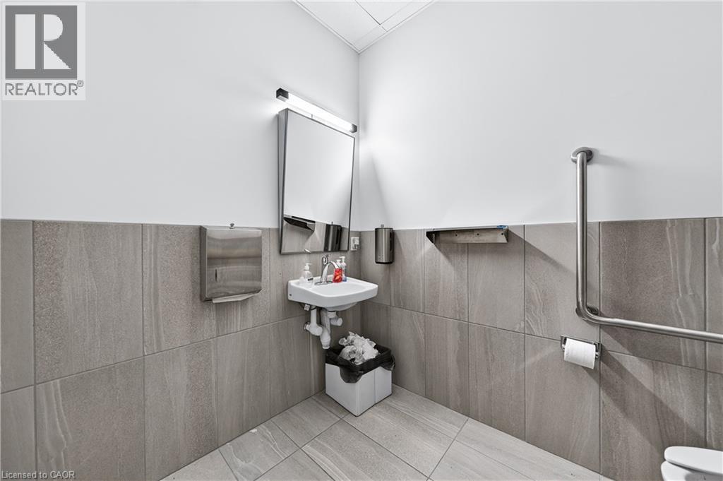 Half bathroom with tile walls and pet washing area - 26 Main Street, Cambridge, ON