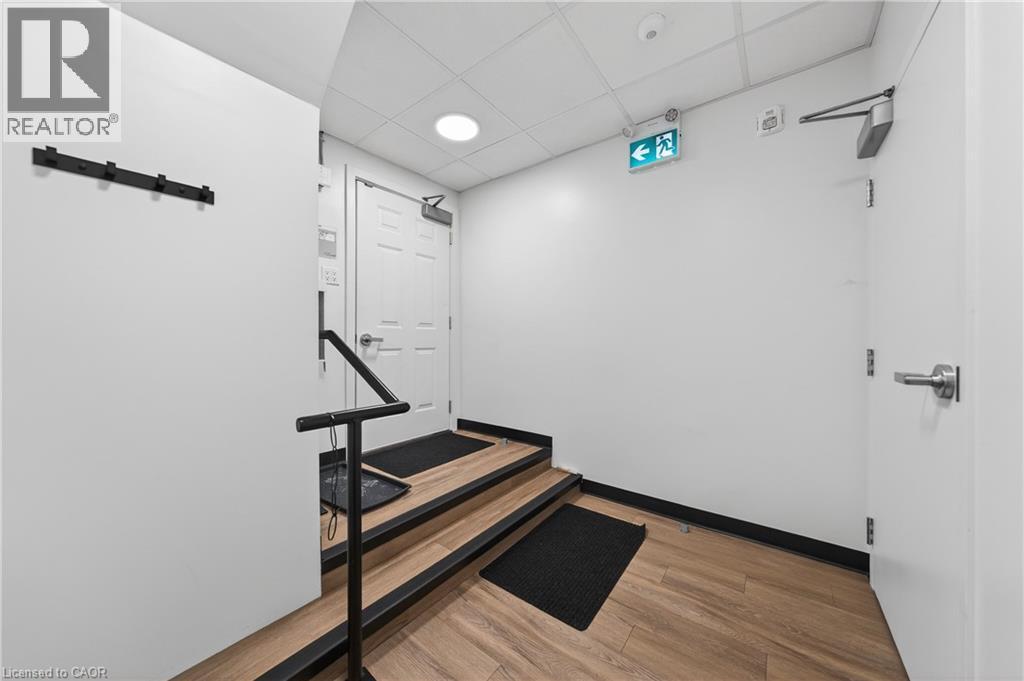 Hallway featuring a drop ceiling, light wood-style floors, and recessed lighting - 26 Main Street, Cambridge, ON