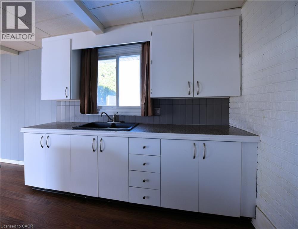 Kitchen featuring white cabinets, dark wood-style flooring, dark countertops, and beam ceiling - 1448 Upper Ottawa Street, Hamilton, ON - Indoor Photo Showing Kitchen