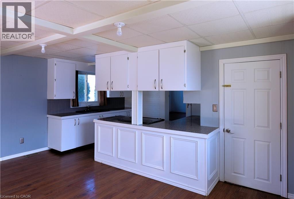 Kitchen with dark countertops, white cabinetry, a peninsula, dark wood finished floors, and black electric cooktop - 1448 Upper Ottawa Street, Hamilton, ON - Indoor