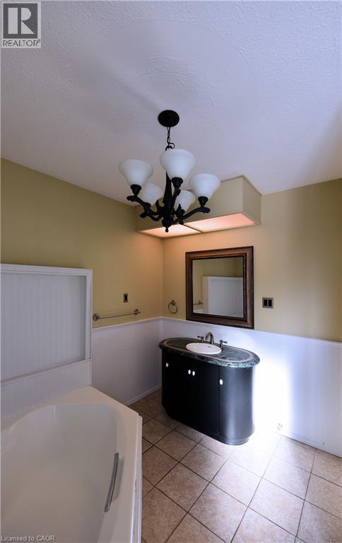 Full bathroom with vanity, a textured ceiling, a garden tub, light tile patterned flooring, and wainscoting - 1448 Upper Ottawa Street, Hamilton, ON - Indoor Photo Showing Other Room