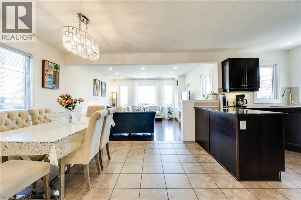 Kitchen with light tile patterned floors, open floor plan, pendant lighting, recessed lighting, and dark stone countertops - 928 Dunblane Court, Kitchener, ON - Indoor Photo Showing Dining Room
