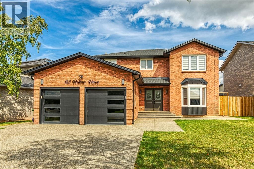 View of front of house featuring brick siding, driveway, a front lawn, and an attached garage - 125 Valera Drive, Hamilton, ON - Outdoor