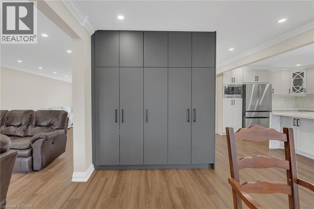 Kitchen with recessed lighting, light wood-style floors, ornamental molding, appliances with stainless steel finishes, and gray cabinetry - 125 Valera Drive, Hamilton, ON - Indoor Photo Showing Other Room