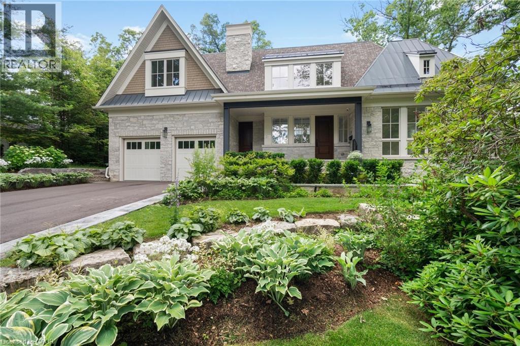 View of front facade with a standing seam roof, a metal roof, stone siding, and a porch - 1322 Minaki Road, Mississauga, ON - Outdoor