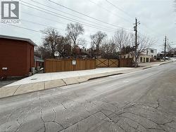 View of asphalt street with sidewalks, a gate, a residential view, and curbs -