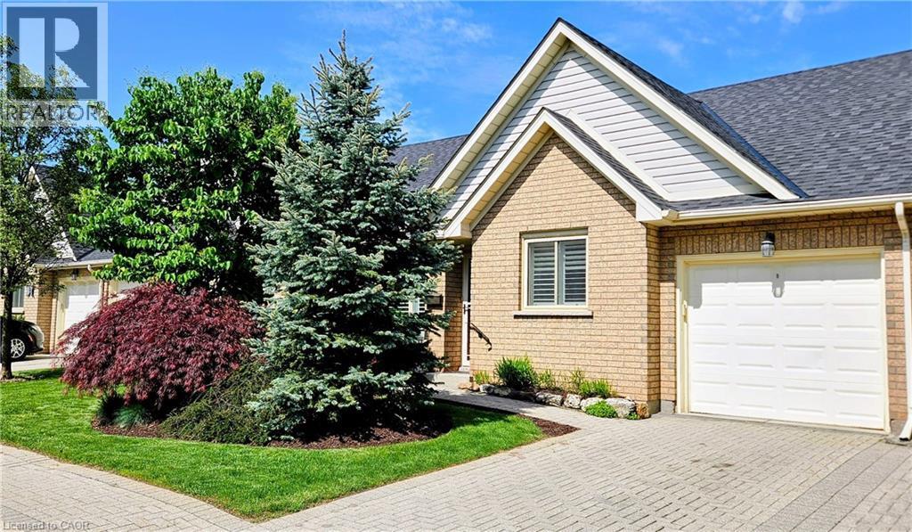 Brick exterior featuring a gabled roofline and light-toned siding - 165 Main Street E Unit# 9, Grimsby, ON - Outdoor
