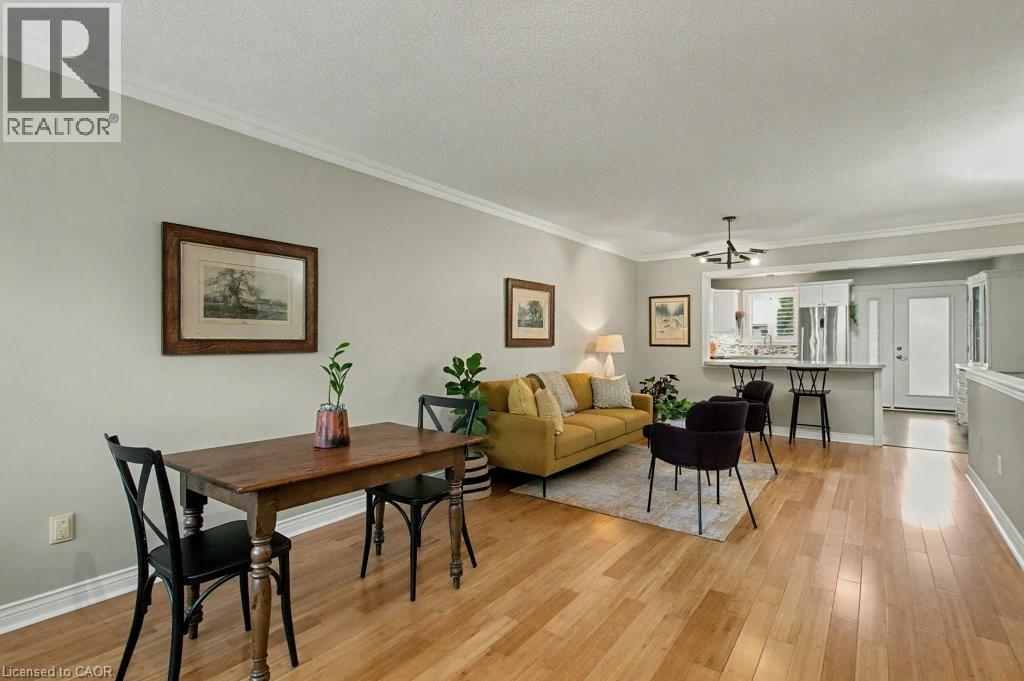 Living area with crown molding, a textured ceiling, and light wood finished floors - 165 Main Street E Unit# 9, Grimsby, ON - Indoor