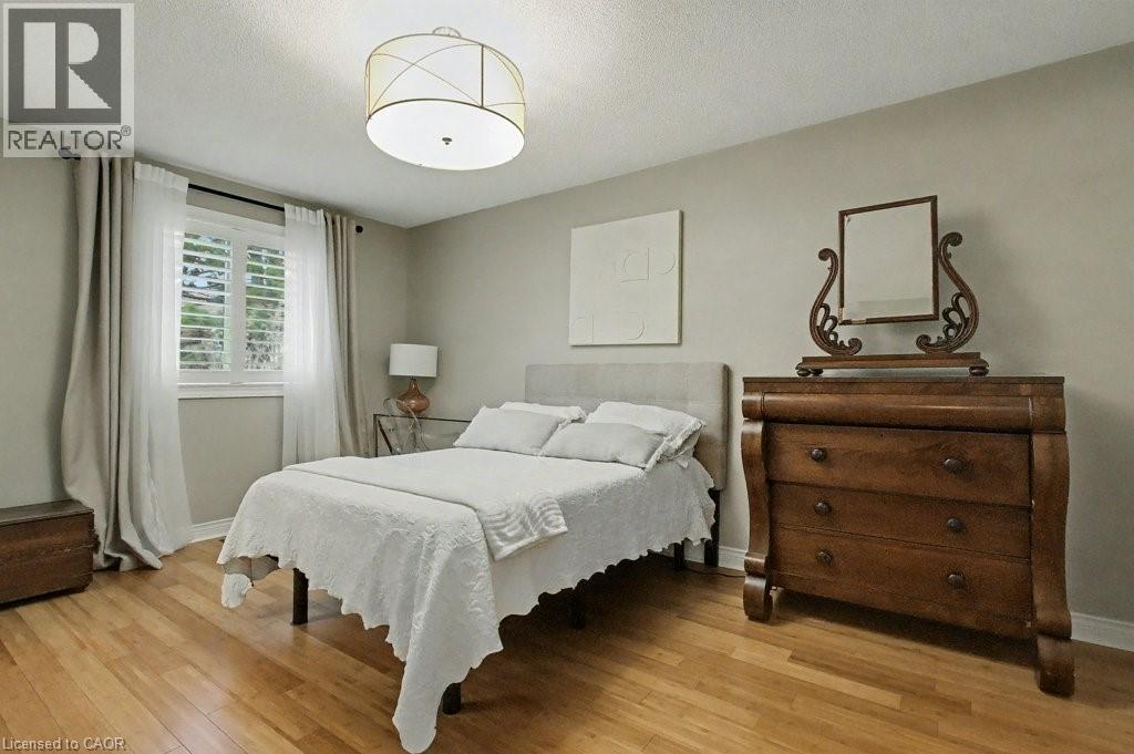 Bedroom with light wood-type flooring and a textured ceiling - 165 Main Street E Unit# 9, Grimsby, ON - Indoor Photo Showing Bedroom