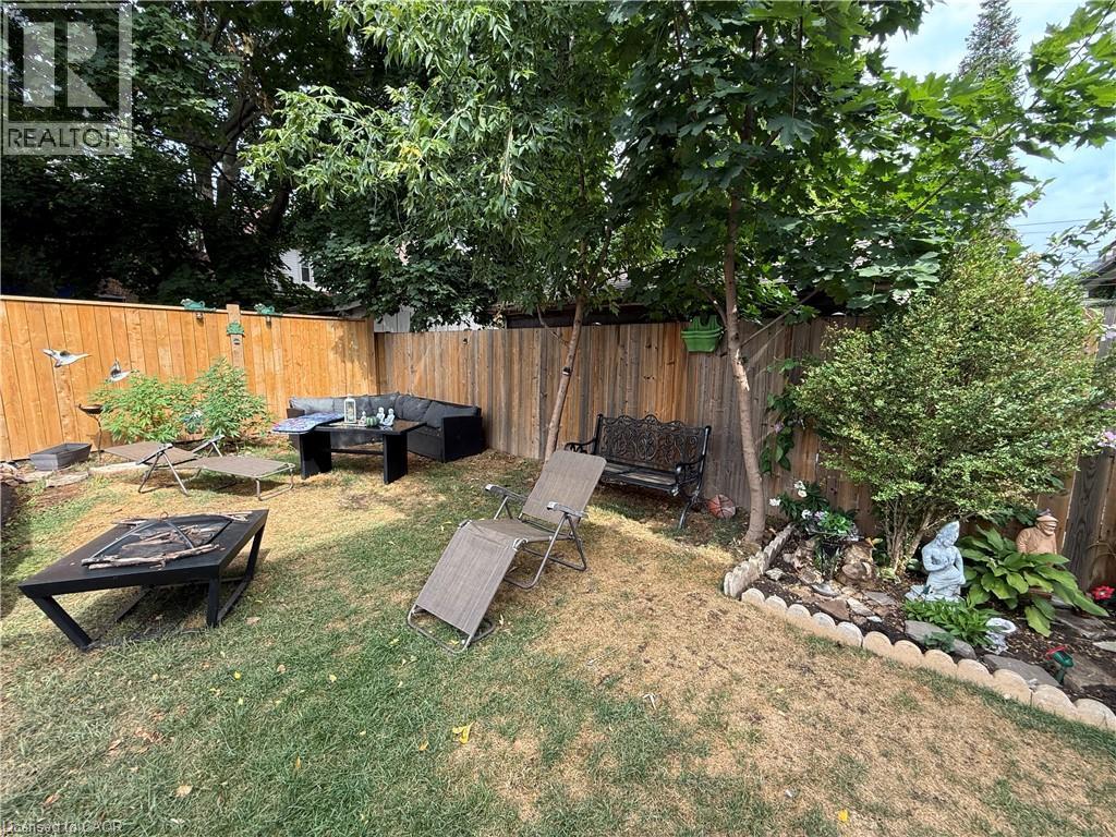 Fenced backyard with an outdoor hangout area - 106 Spadina Avenue Unit# 1, Hamilton, ON - Outdoor