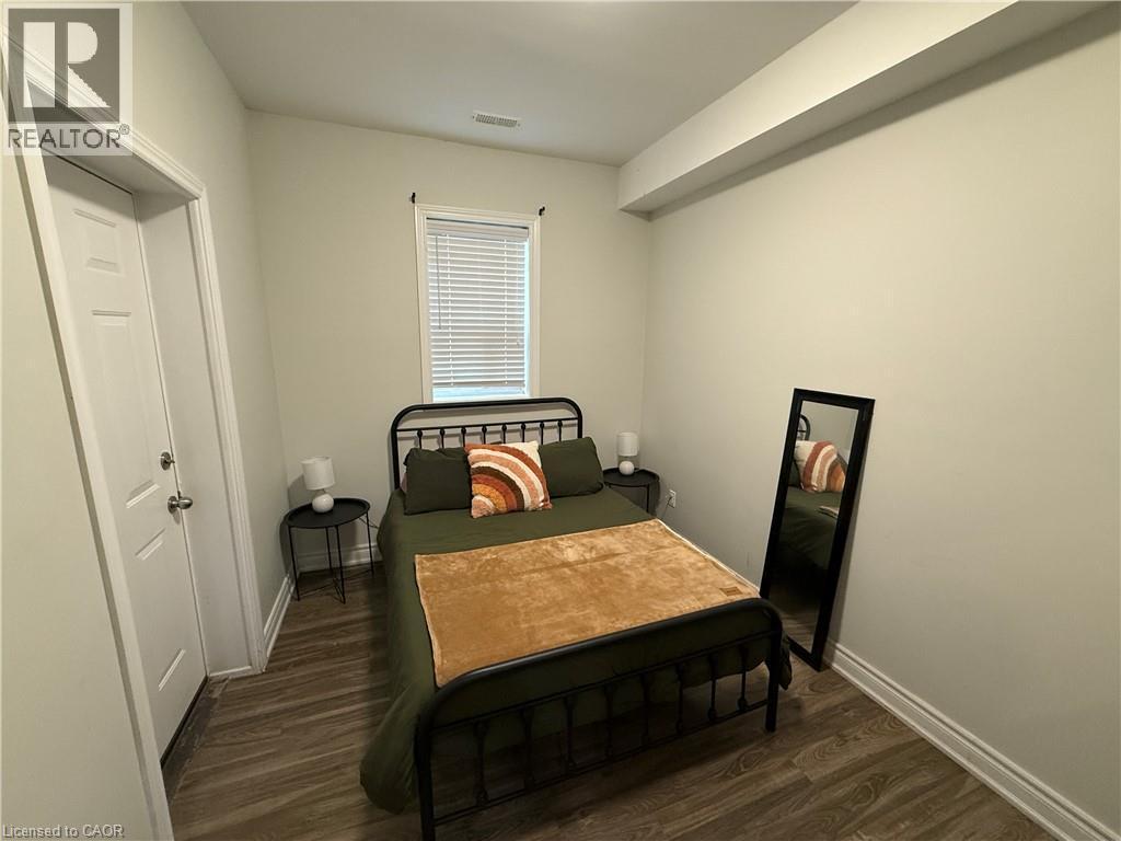 Bedroom featuring dark wood-style floors and baseboards - 106 Spadina Avenue Unit# 1, Hamilton, ON - Indoor
