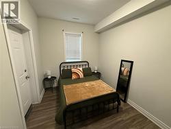 Bedroom featuring dark wood-style floors and baseboards -