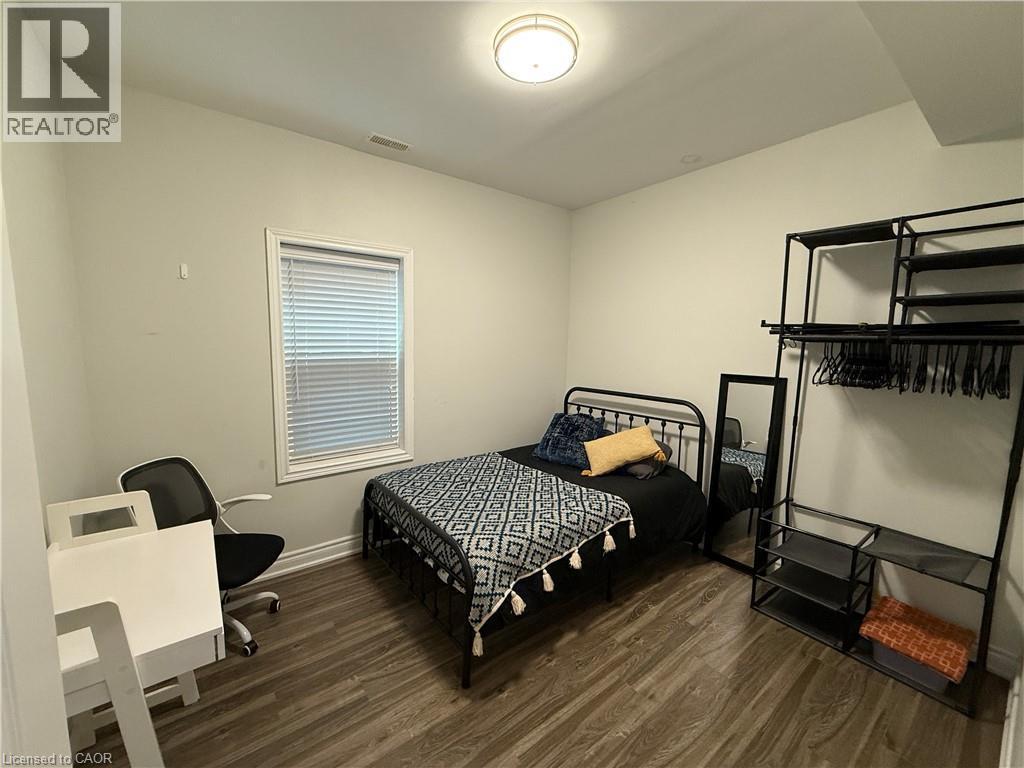Bedroom with dark wood-style flooring and an office area - 106 Spadina Avenue Unit# 1, Hamilton, ON - Indoor Photo Showing Bedroom