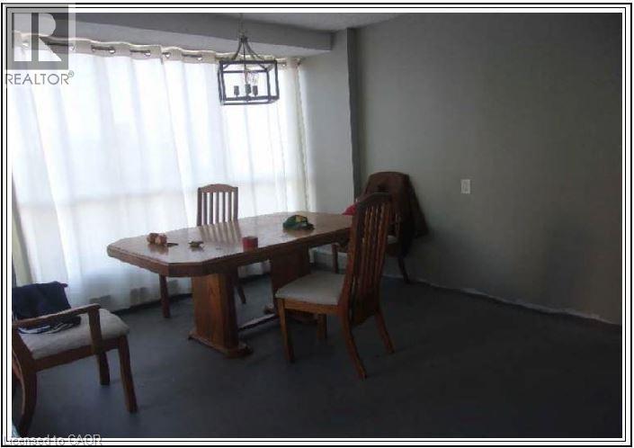 Dining room with carpet flooring and a chandelier - 150 Charlton Avenue E Unit# 708, Hamilton, ON - Indoor Photo Showing Dining Room