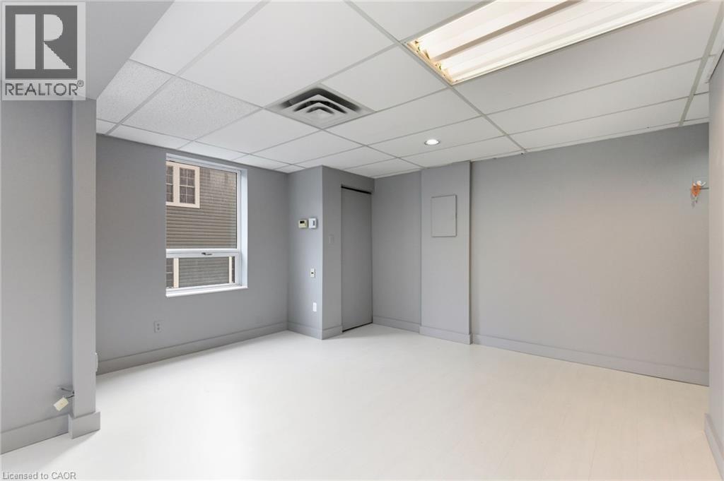 Below grade area with a paneled ceiling and baseboards - 17 King Street E Unit# 205, Dundas, ON
