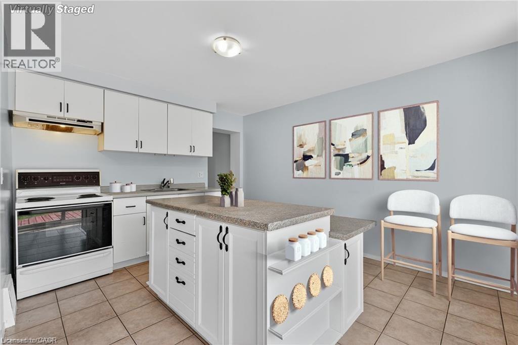Kitchen featuring electric stove, white cabinetry, under cabinet range hood, and light tile patterned floors - 111 Hillyard Street, Hamilton, ON - Indoor Photo Showing Kitchen