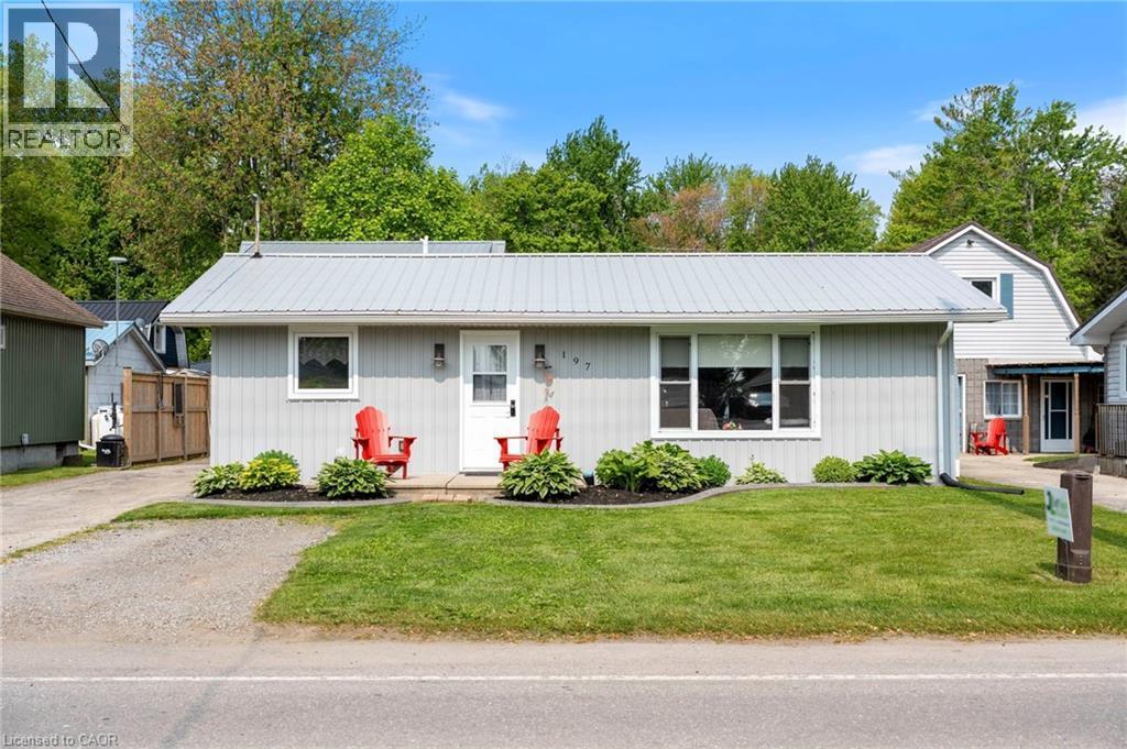 View of front of home with a metal roof, a front lawn, and board and batten siding - 197 Cedar Drive, Turkey Point, ON - Outdoor With Facade